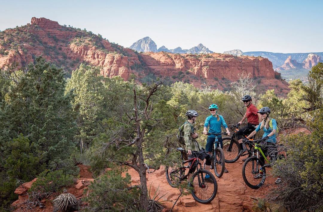 A group of riders having fun riding mountain bikes in the mountains on a hilltop.