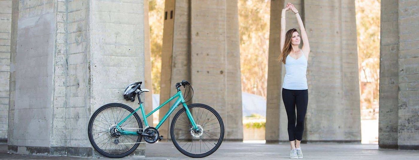 Side View of a sport Hybrid Bike with a Woman doing stretch fitness.